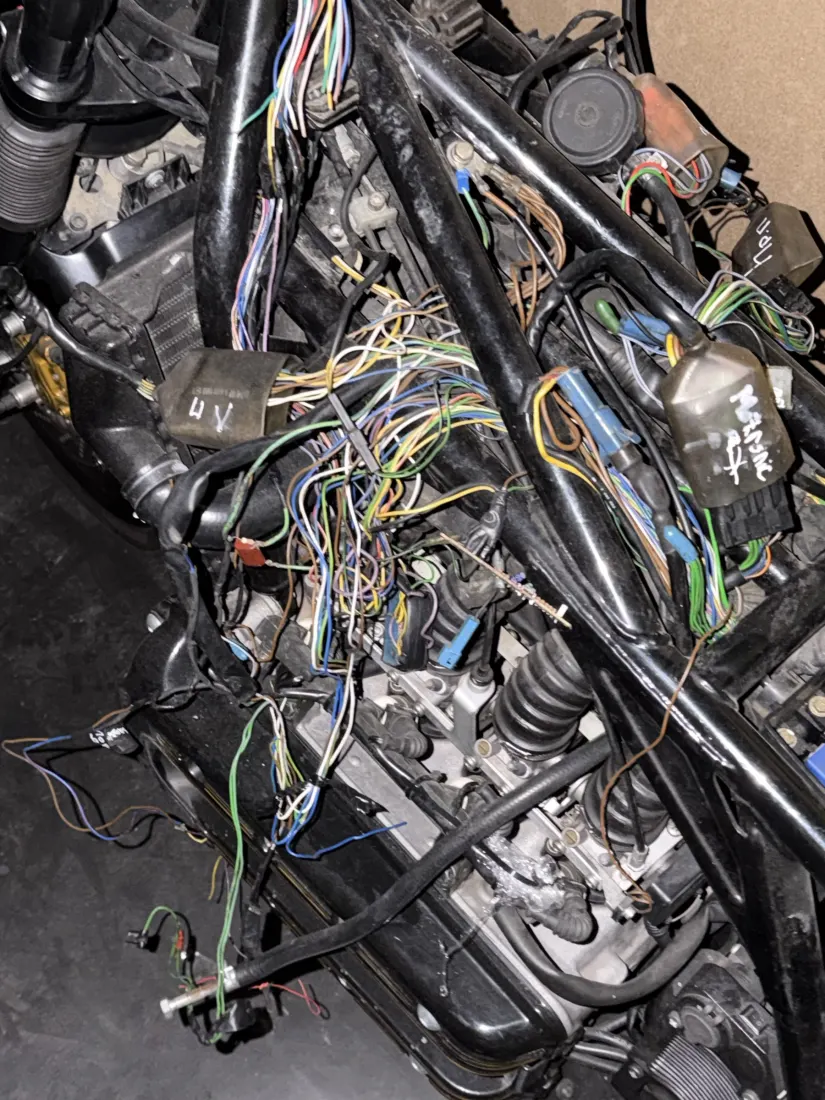 A motorcycle with its wiring loom exposed, mid-repair