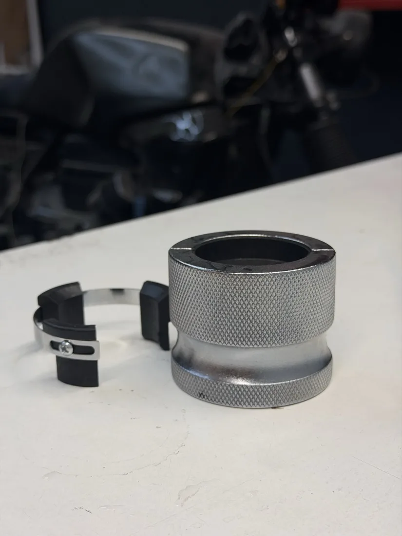 A knurled universal fork seal driver and its adjustable collar on the bench